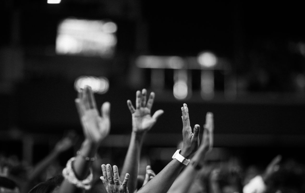 grayscale-photography-of-people-raising-hands-2014775.jpg
